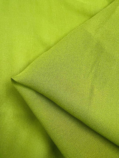 A close-up of Super Cheap Fabrics' Silk Georgette in Evergreen (135cm), showcases its folded texture. The lightweight silk features a smooth, slightly shiny surface, and the lighting accentuates its subtle weave pattern, making it an ideal choice for spring summer fashion.