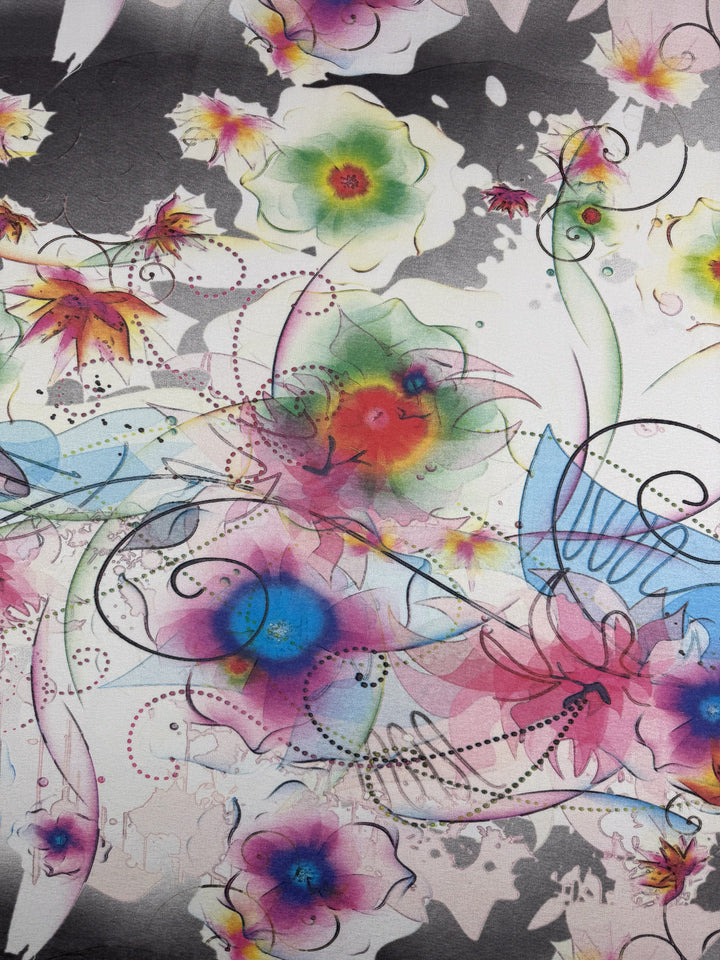 Super Cheap Fabrics’ Viscose Knit - Watercolour Bloom (142cm) features pink, purple, green, and blue watercolor florals with black lines and dots on white—an artistic, breathable summer fabric blending vivid and muted tones.