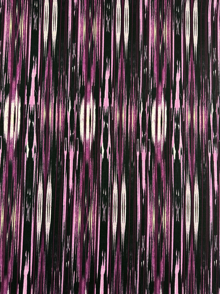 A dynamic and abstract visual effect is achieved with the "Dashing Lights" pattern on this medium-weight Printed Lycra fabric from Super Cheap Fabrics, blending vibrant vertical streaks of pink, purple, black, and occasional white accents.