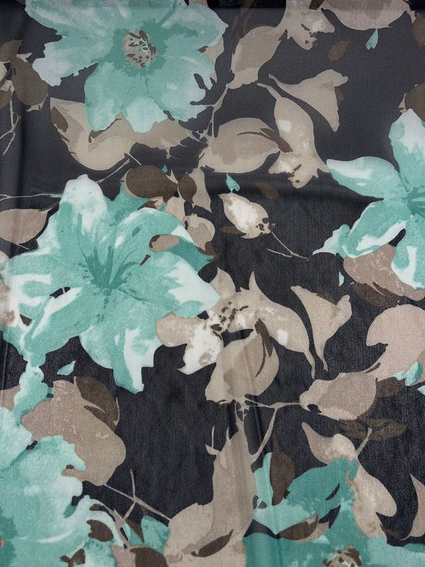 A close-up photo of the lightweight Printed Mesh - Lilly - 145cm from Super Cheap Fabrics, showcasing a floral pattern. The design features large teal and green flowers with tan and beige leaves on a dark gray background. The flowers and leaves are scattered evenly across the printed mesh, creating a balanced and harmonious look.