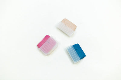 Three Tailors Chalk in Holders from Super Cheap Fabrics, featuring pink, beige, and blue colors partially encased in transparent plastic holders with ribbed edges for easy gripping, are displayed on a plain white background.