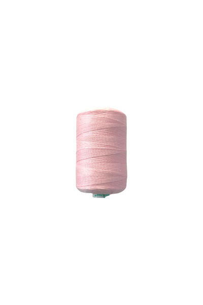 A spool of Super Cheap Fabrics' "Thread - Baby Pink" sewing thread is centered against a plain white background. The spun polyester is tightly wound around the cylindrical spool and measures 1000 meters. The color of the thread appears soft and pastel.