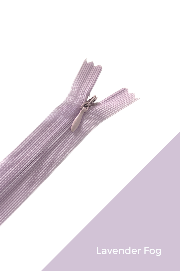 A close-up image of a durable, lavender-colored zipper partially undone, set against a white and lavender background. In the bottom right corner, a diagonal lavender section displays the text "Super Cheap Fabrics - Invisible Zip - 30cm - Purples.