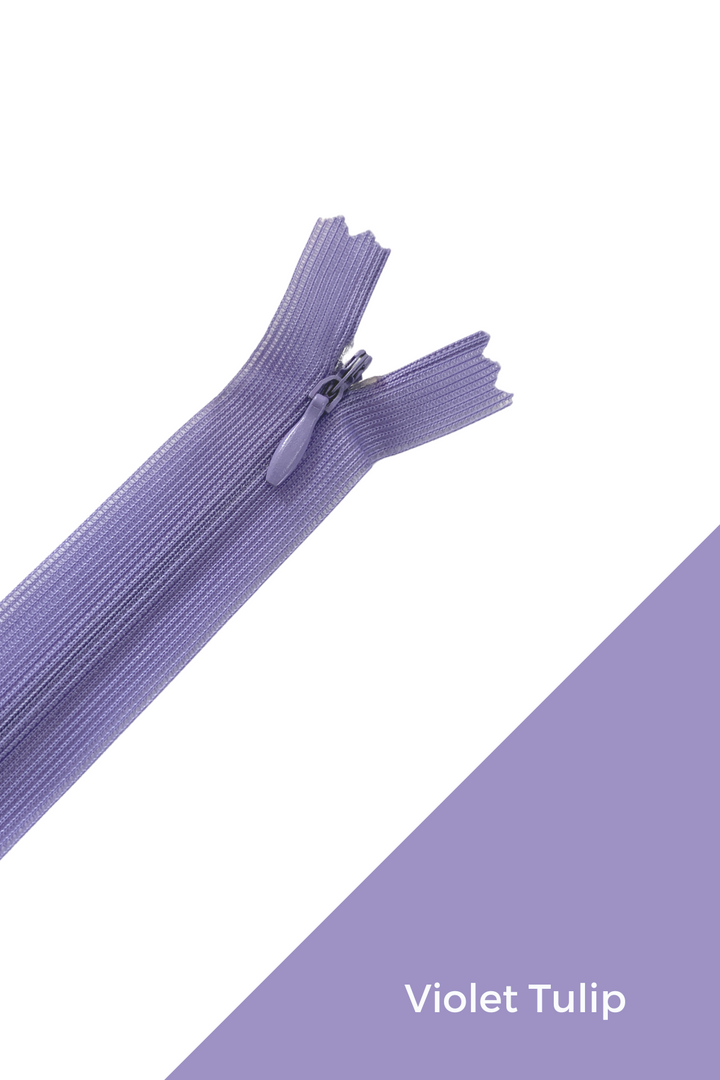 A close-up shot of a violet-colored, durable zipper from Super Cheap Fabrics' "Invisible Zip - 30cm - Purples" collection, partially unzipped and positioned diagonally on a white and violet background. The text "Violet Tulip" appears on the violet section of the background in the bottom right corner, enhancing the image with an elegant touch of sophistication.